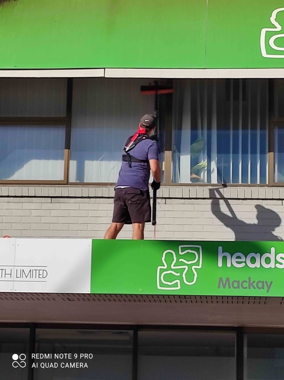 A man cleaning the glass frontage of a shop