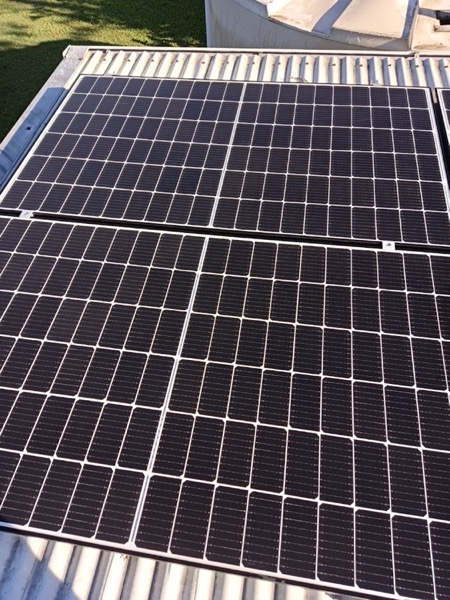 A close-up of roof solar panels with water running across them