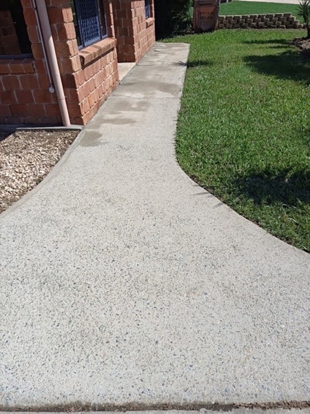A concrete path running beside a lawn