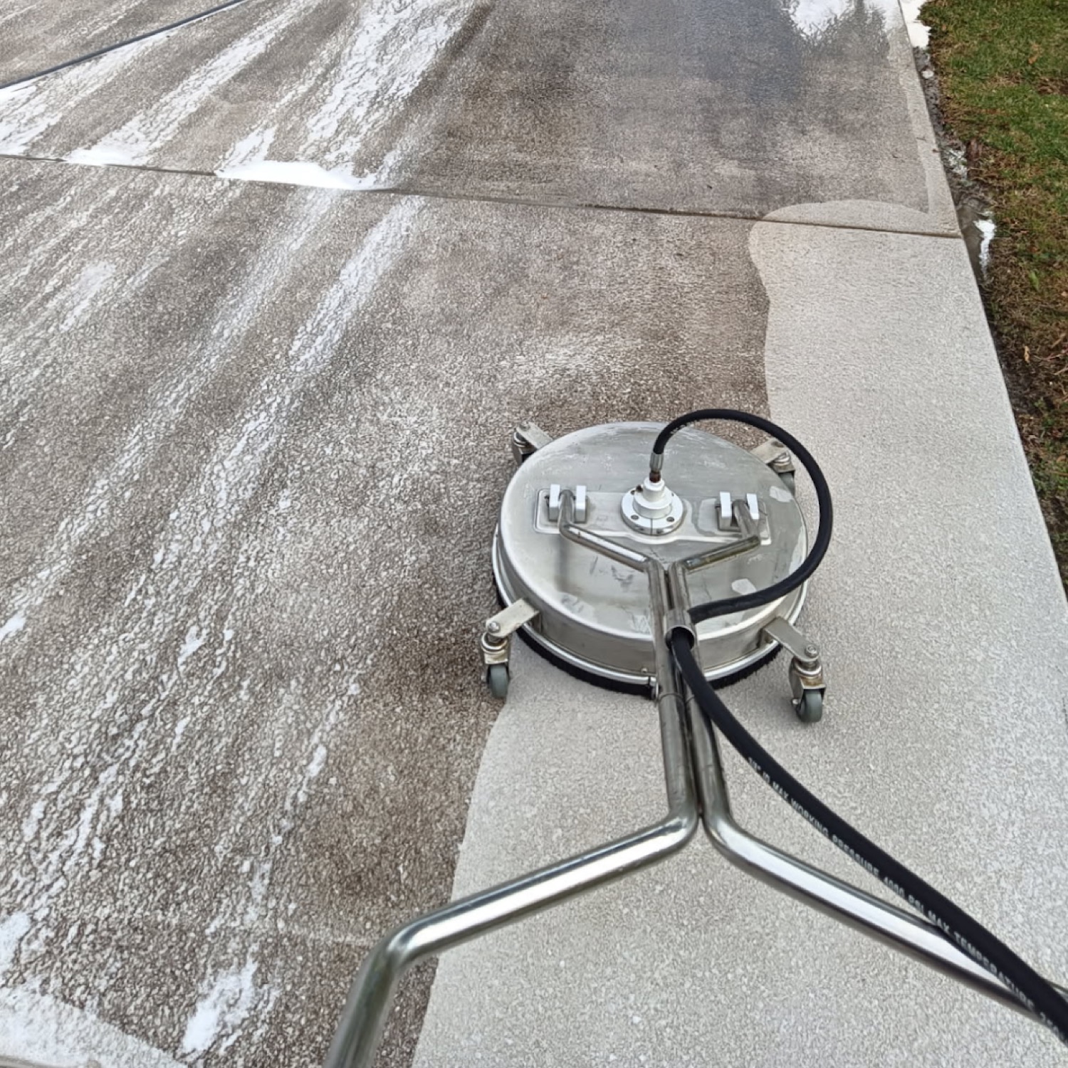 A rotary surface cleaner on a concrete driveway